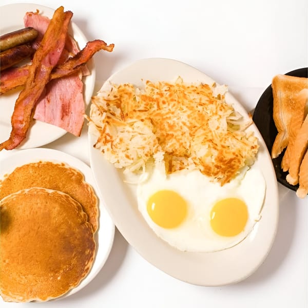 Ted's Coney Island breakfast with pancakes, bacon, sausage, ham, hash browns, fried eggs, and toast.