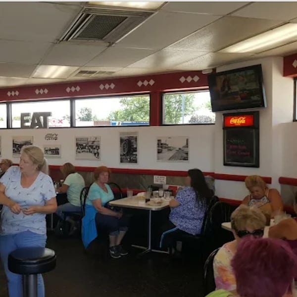 Diners seated at tables in Ted's Coney Island, a brightly lit diner with large windows.