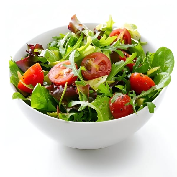 Fresh mixed greens salad with cherry tomatoes in a white bowl, a healthy side at Ted's Coney Island.